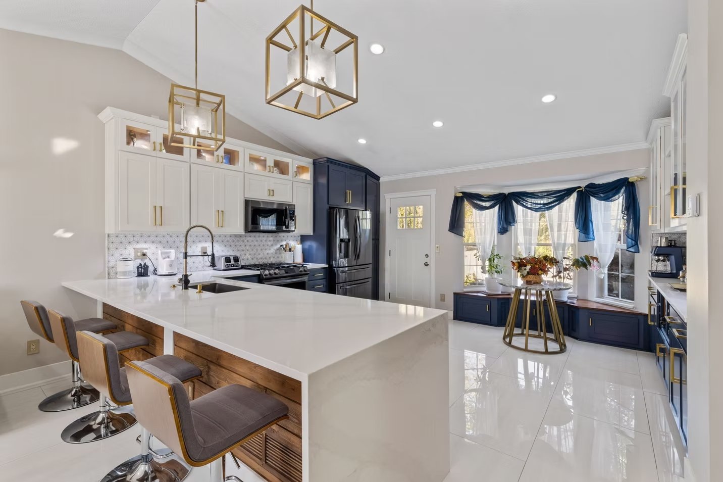 J & R completed kitchen with navy cabinetry and a white stone waterfall island