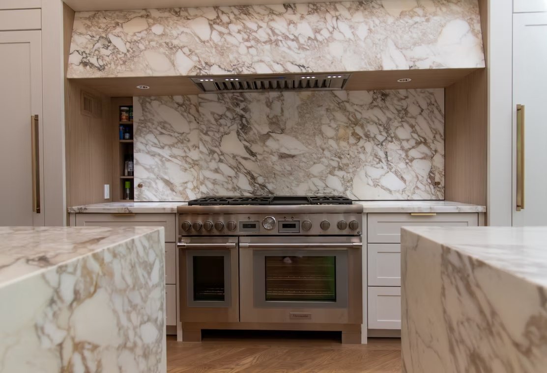 J & R completed kitchen with a precisely fitted veined stone backsplash around the range