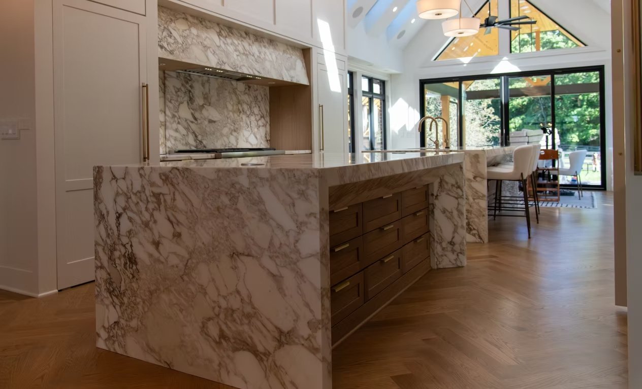 J & R stone island with dramatic natural-looking veining and warm wood cabinets